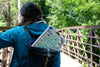 Maine puzzle in a backpack of a women cross a bridge in nature.