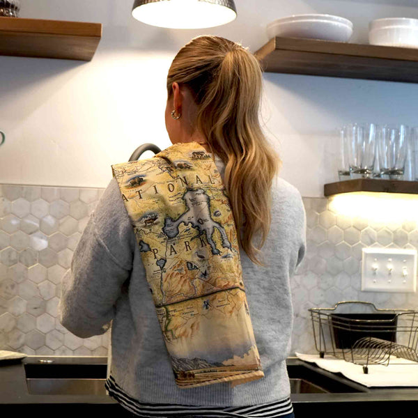 Kitchen Setting: A women Washing Dishes with a Yellowstone National Park Kitchen Towel on her shoulder.