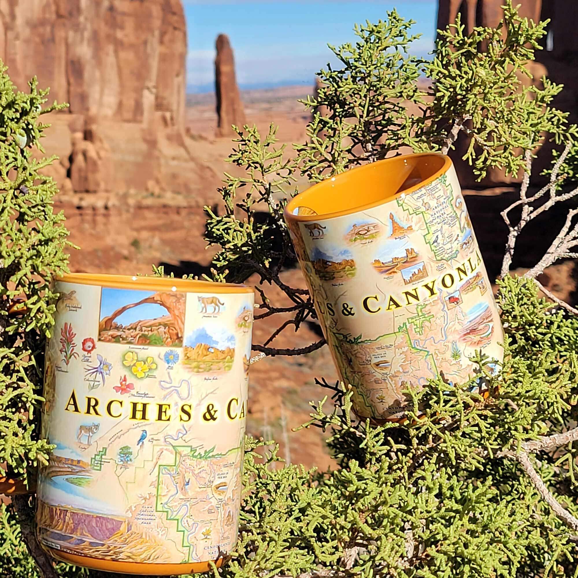 Arches and Canyon lands coffee mugs sitting in juniper trees in Utah's national park.