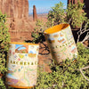 Arches and Canyon lands coffee mugs sitting in juniper trees in Utah's national park.