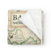 Banff National Park Map Fleece Blanket in earth-tone colors. This map highlights Lake Louise, Moraine Lake, Lake Minnewanka, Peyto Lake, Emerald Lake, Mount Rundle, Mount Assiniboine, Cascade Mountain, Castle Mountain, Mount Temple, and Fairmont Banff Springs Hotel. Wildlife includes elk, mountain lions, Bald Eagles, gray wolves, Bighorn Sheep, black & Grizzly bears, moose, Great Horned owls, beavers, and more.