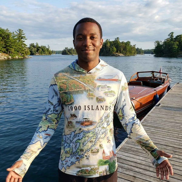 Person wearing a '1000 Islands' themed shirt by a lake with a boat and dock in the background.