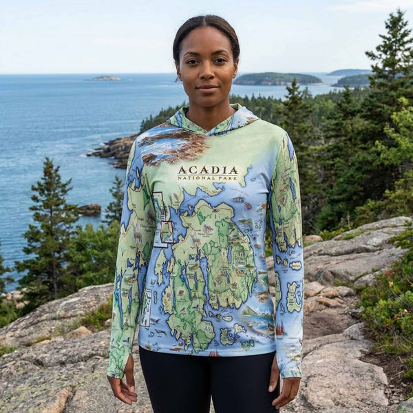 Person wearing a sun shirt hoodie with Acadia National Park design in a scenic outdoor setting.