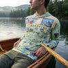 Person wearing a sun shirt hoodie with Adirondacks design, sitting in a boat on a lake.