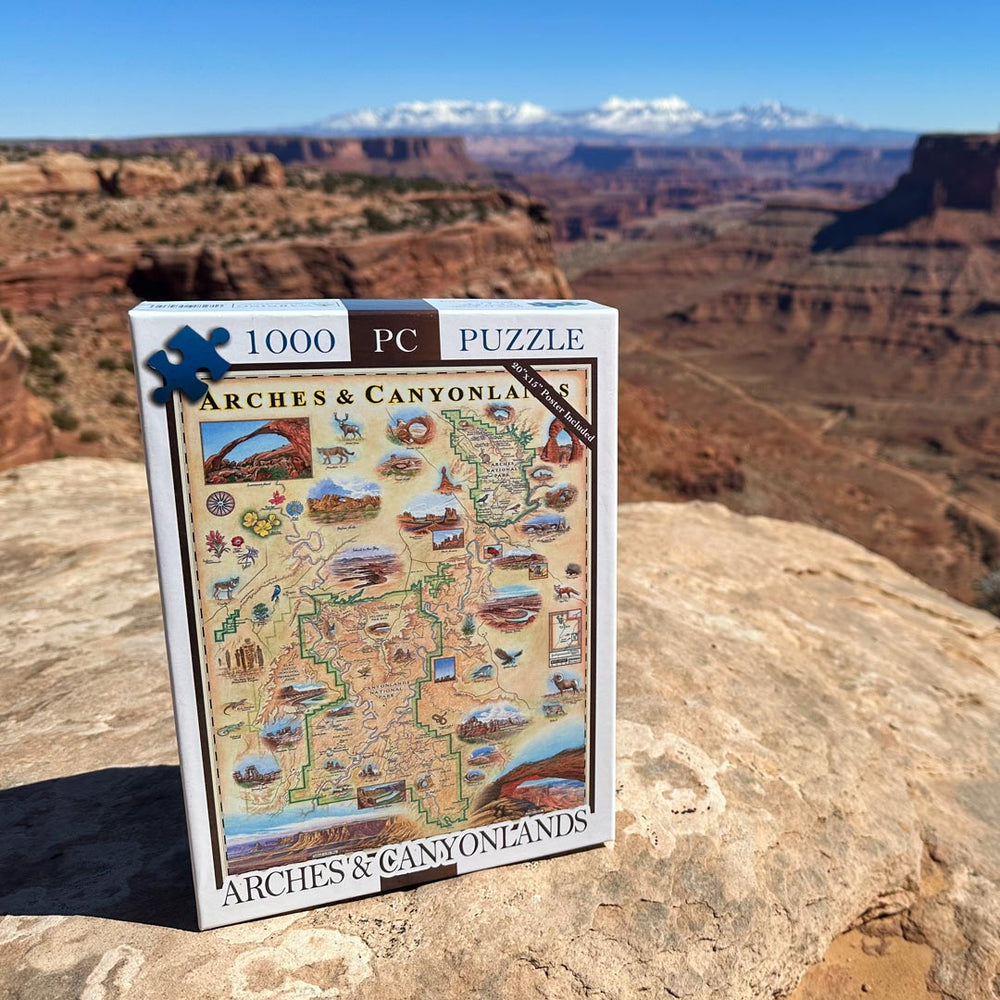 Arches and Canyonlands National Park puzzles sitting on a rock over looking a canyon in the park.