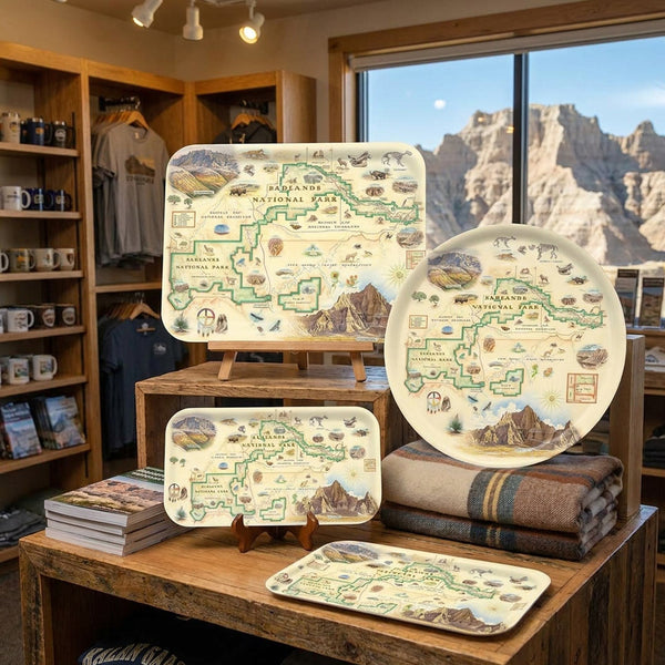 Set of Badlands serving trays with map design on a wooden table in a store with mountain view