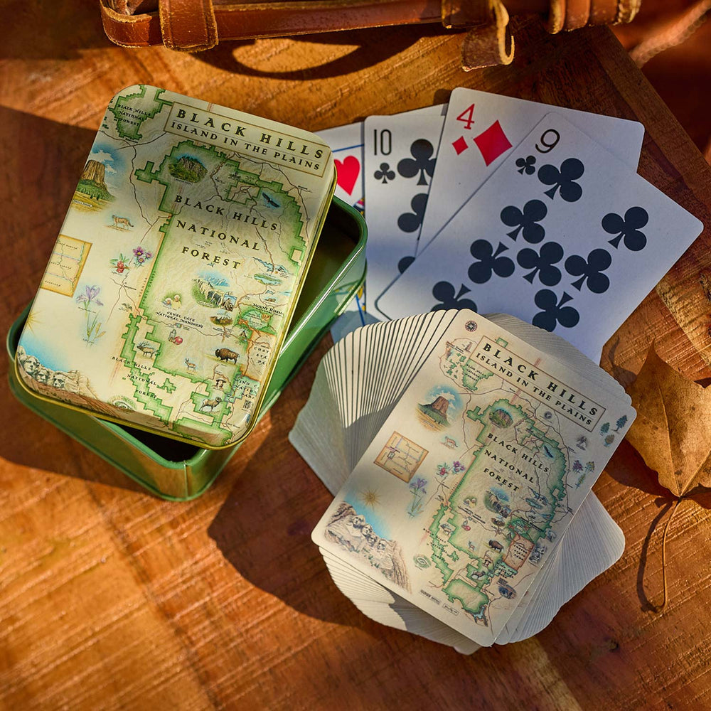 Playing cards with Black Hills National Forest design on a wooden surface