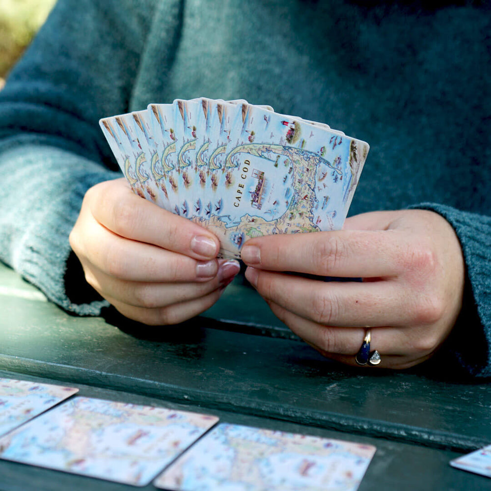 Woman playing cards with the Cape Cod map deck.