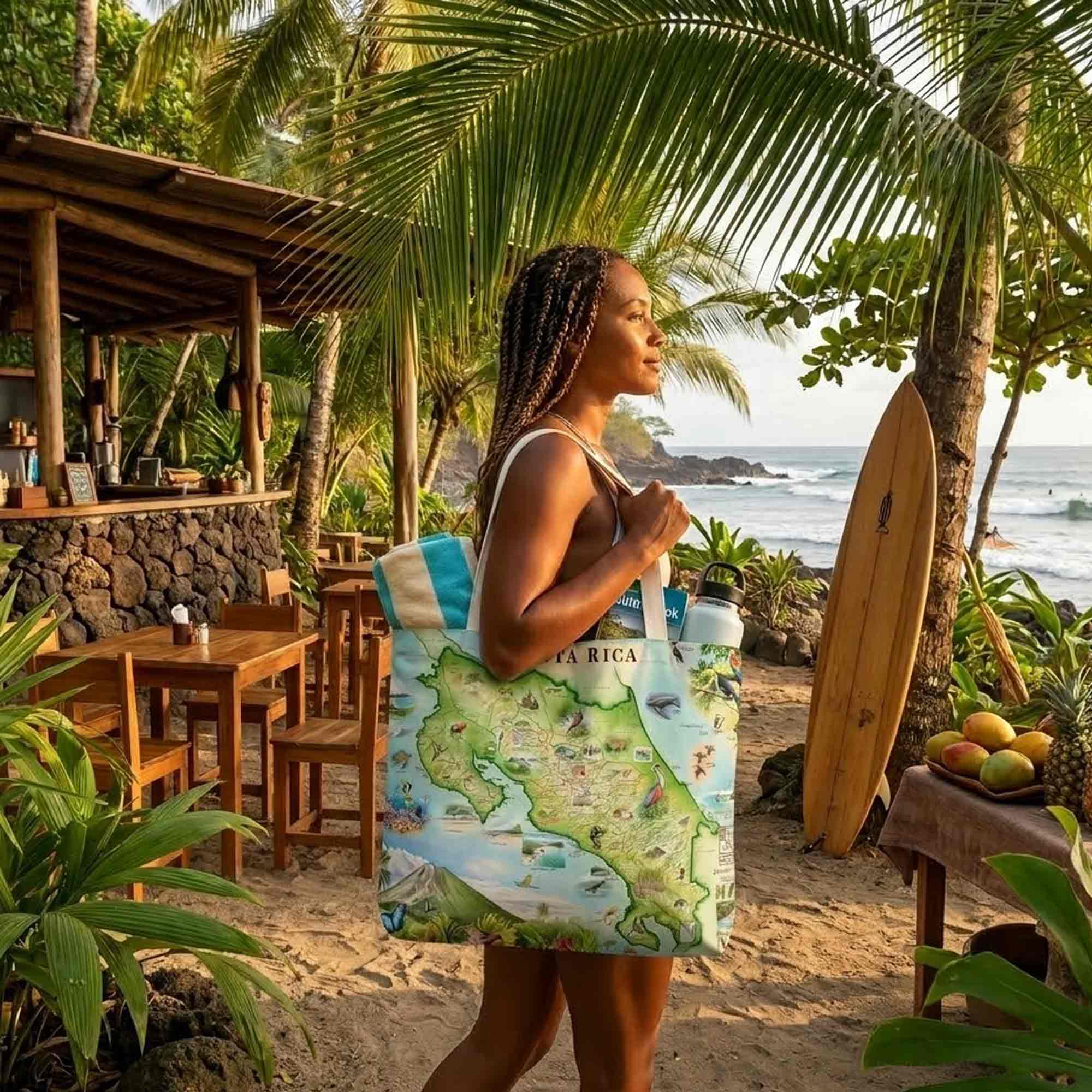Woman holding a tote bag with a map design on a tropical beach.