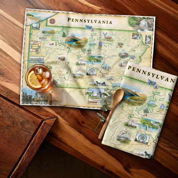 Pennsylvania-themed kitchen towel on a wooden surface with a drink.