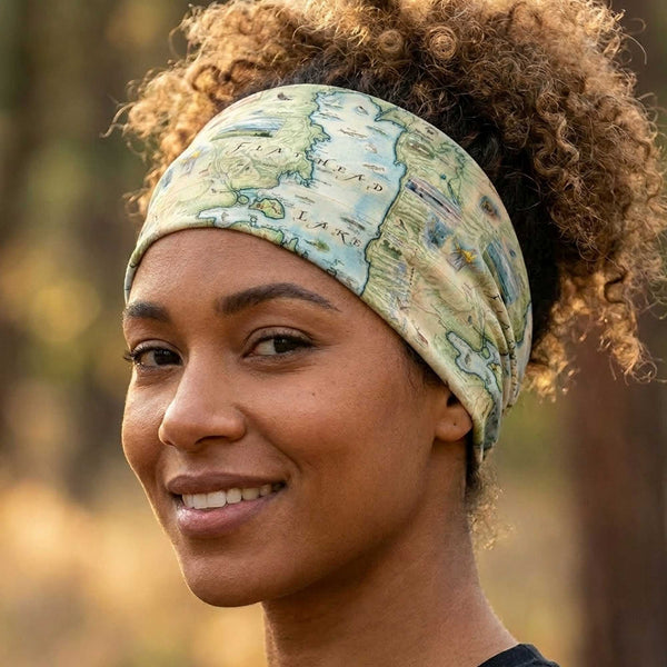 Woman wearing a Flathead Lake map design gaiter as a headband with a blurred natural background