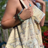 A woman carrying a Flathead Lake Montana Map Canvas Tote Bag 
