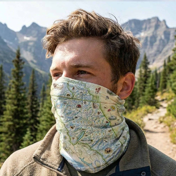 Person wearing a map-patterned face covering in a mountainous outdoor setting