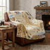 Map-themed blanket draped over a brown leather chair in a cozy living room.