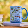 Mug with Grand Teton National Park design on a book against a blurred natural background