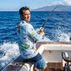 Man fishing on a boat in the Hawaiian Pacific Ocean with a scenic background