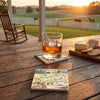 Glass of whiskey with a Kentucky map coaster on a wooden table with a scenic background