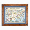 A framed vintage-style map of the United States of America, featuring a detailed illustrated map with state outlines, landmarks, and historical motifs, surrounded by a blue mat and a rustic brown wooden frame.