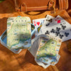 Playing cards with a map of Maine on a wooden surface