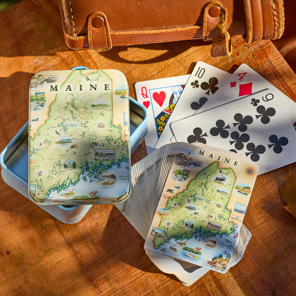 Playing cards with a map of Maine on a wooden surface