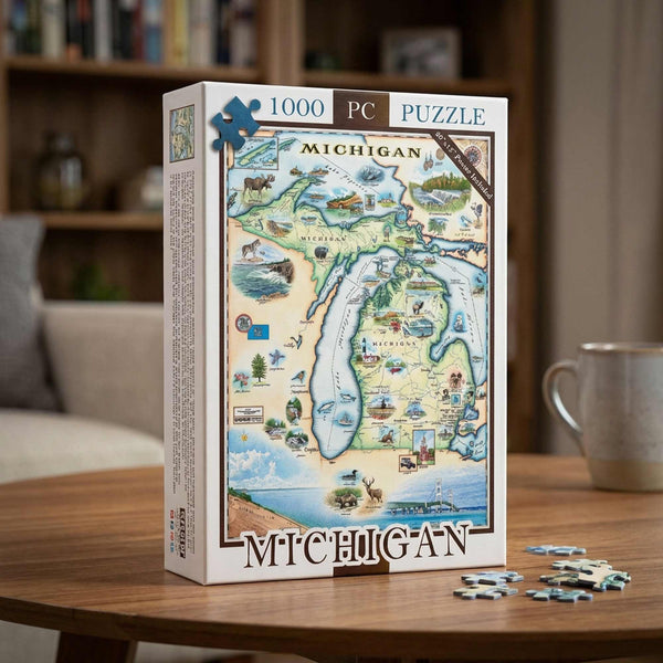 A 1000-piece jigsaw puzzle box featuring a colorful illustrated map of Michigan, displayed on a wooden table with a few loose puzzle pieces in front. A blurred living room background with a bookshelf and a mug is visible.