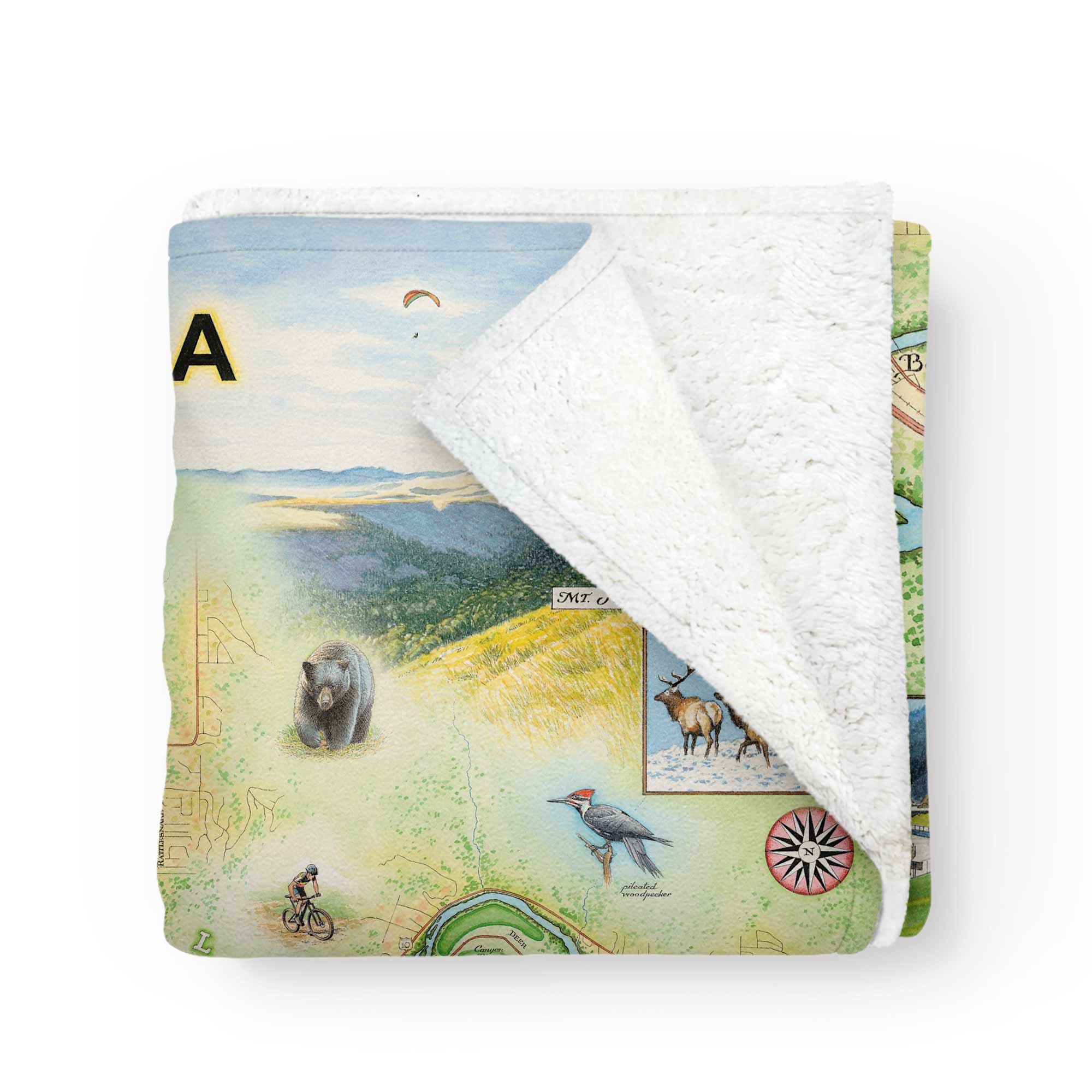 Missoula map fleece blanket featuring hand-drawn artwork by Xplorer Maps, folded to reveal soft white fleece lining in the top corner.