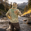 Person fishing in a mountainous area with a Montana map hoodie and waders.
