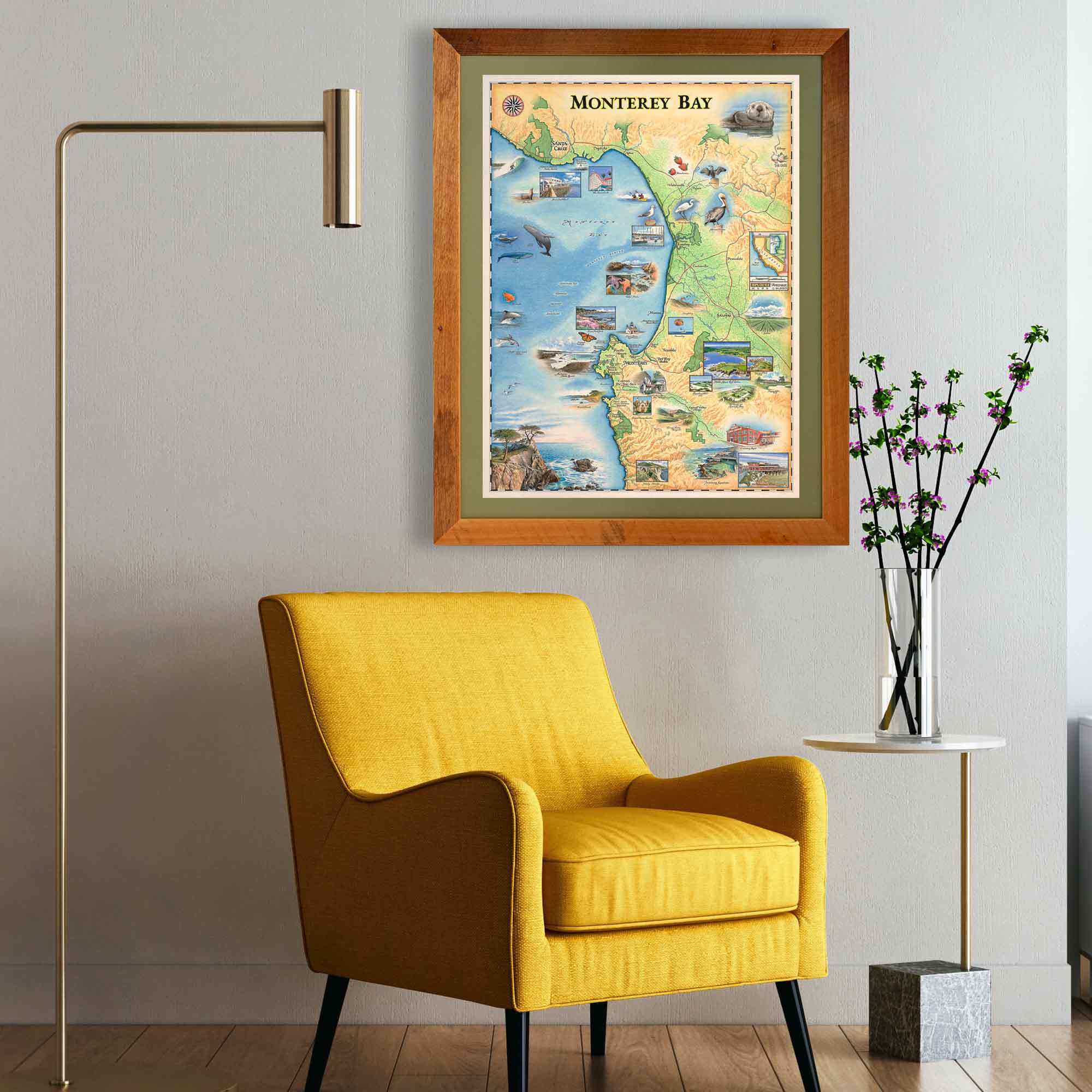 Monterey Bay framed map hanging on a wall over a yellow chair. 