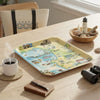 Monterey Bay  tray with a map design on a wooden table with a cup of coffee, notebook, and binoculars.