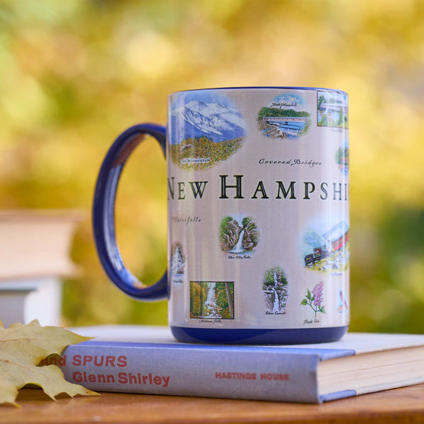 Mug with New Hampshire design on a book with a blurred natural background