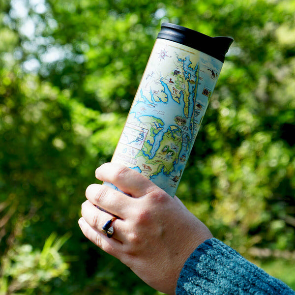 A person holding Outer Banks travel tumbler with hand-drawn map design by Xplorer Maps in the park. 