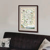 Rocky Mountain National Park map framed hanging on a wall above a grey couch.