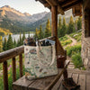 Tote bag with Rocky Mountain National Park design on a wooden bench with scenic mountain view.
