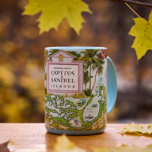 Decorative mug with Captiva and Sanibel Island design on a wooden surface with autumn leaves.