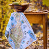 Map of Santa Catalina Island draped over a wooden table with a bowl and snacks in an outdoor setting.
