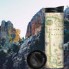 Black Hills National Forest Map Travel Thermos. In the background is Mount Rushmore with President George Washington. The map Features cities like Rapid City, Spearhead, Rapid City, and Sturgis. Mount Rushmore, Devils Tower, Jewel Cave National Monument, Custards, and Wind Cave National Park. Flora and Fauna illustrations include bison, elk, mountain goats, birds, pine trees, and native flowers. 