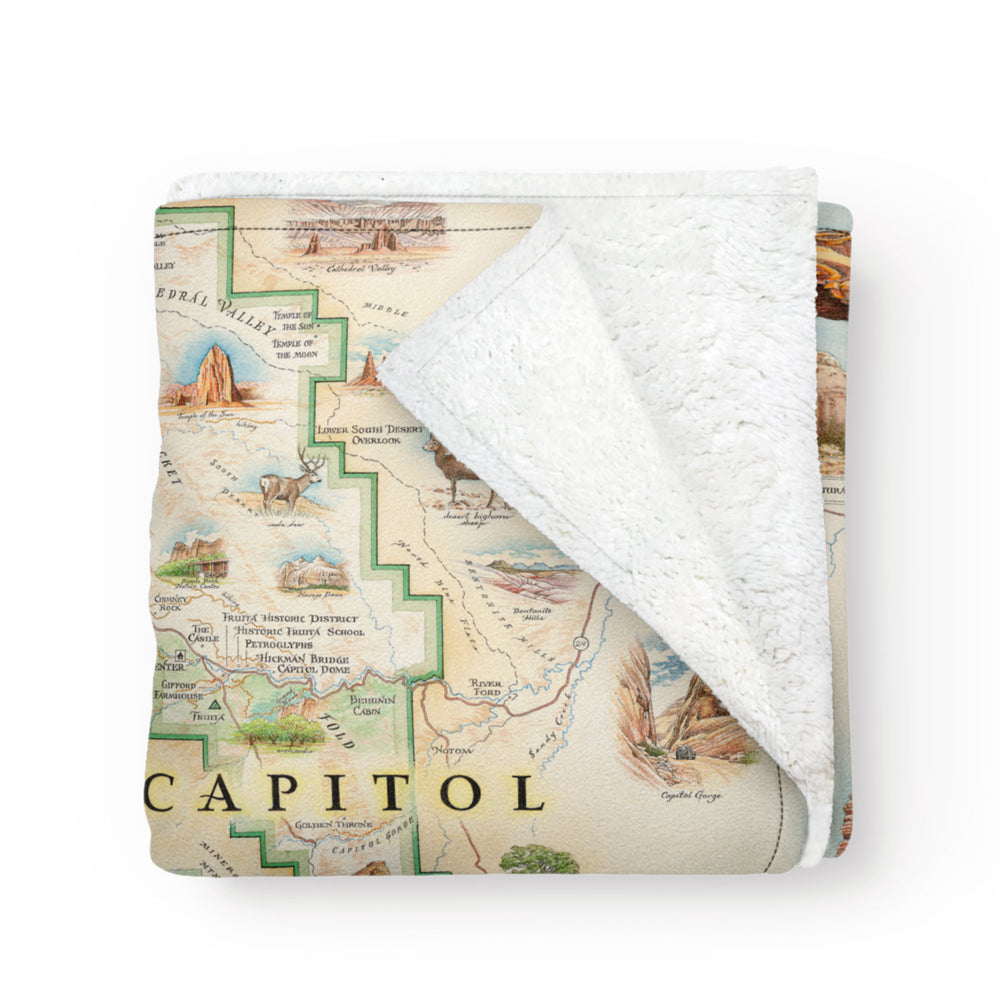 Utah's Capitol Reef National Park Map fleece blanket in earth tones. Featuring Claret Cup Cactus, Narrowleaf Yucca, Prince's Plume, and the Two-Needle Pinyon Pine. Detailed depictions of landmarks and geographic wonders like the Lower Muley Twist Canyon, Capitol Gorge, and Hickman Natural Bridge. Measures 58"x50."
