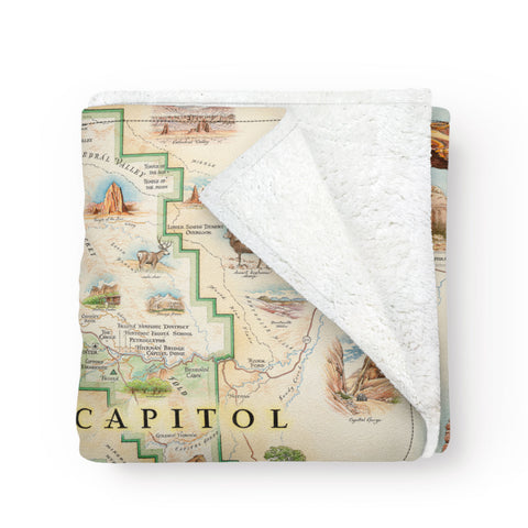Utah's Capitol Reef National Park Map fleece blanket in earth tones. Featuring Claret Cup Cactus, Narrowleaf Yucca, Prince's Plume, and the Two-Needle Pinyon Pine. Detailed depictions of landmarks and geographic wonders like the Lower Muley Twist Canyon, Capitol Gorge, and Hickman Natural Bridge. Measures 58"x50."